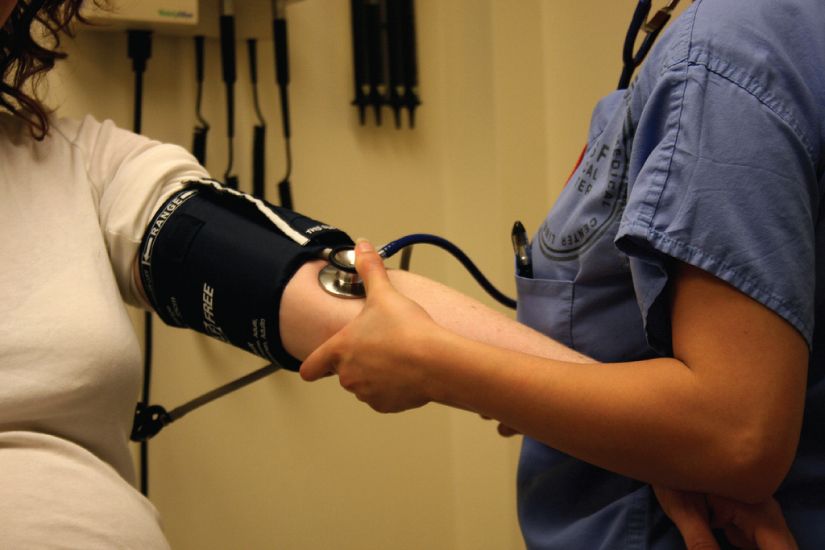 A blood pressure measurement being taken with cuff and stethoscope reference figure