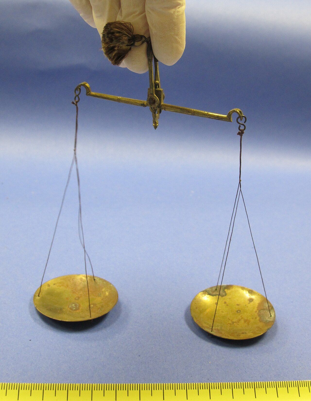 A set of brass balance scales weighing objects on two pans, symbolizing the weighing of costs and benefits