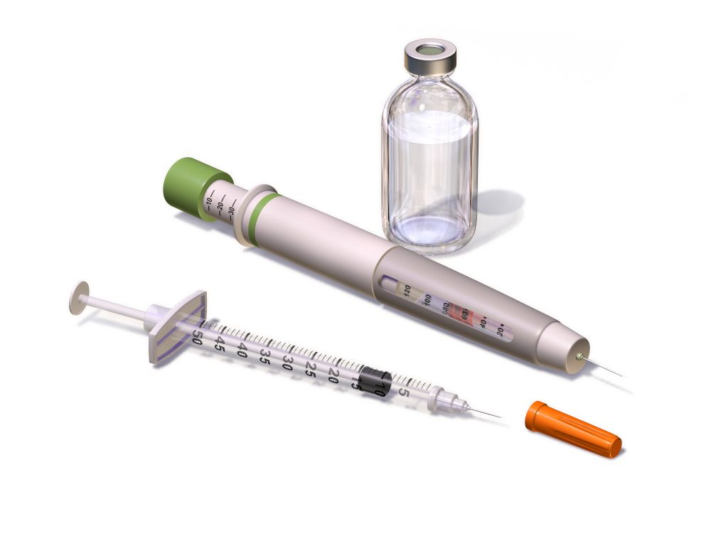An oral dosing syringe drawing liquid medication from a bottle beside a paediatric weight record