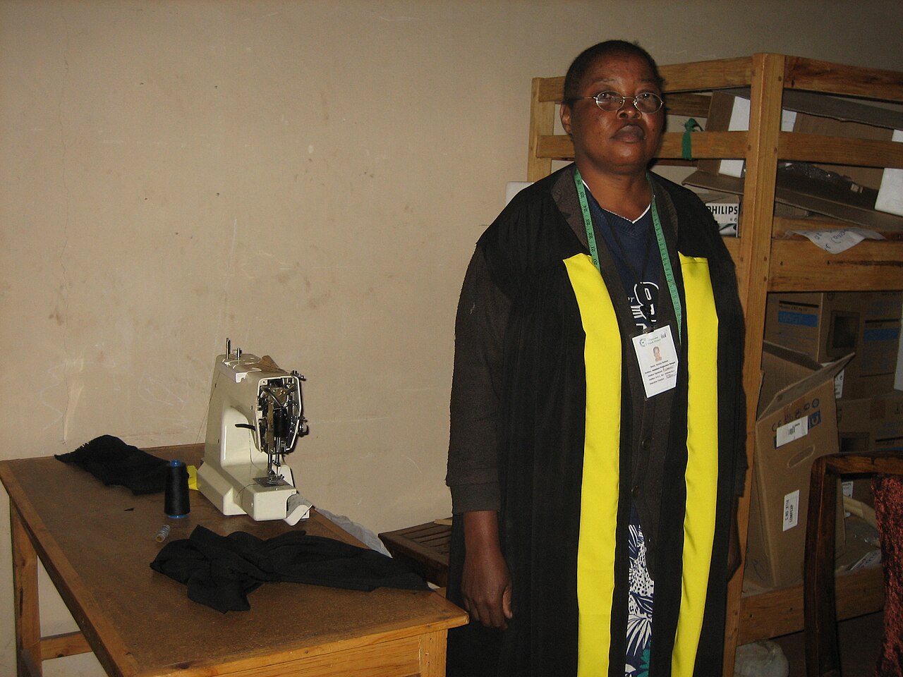 A woman teaching tailoring to others in a community workshop